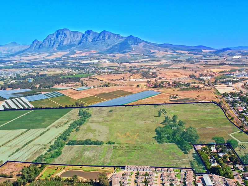 An aerial view of a large, undeveloped residential land parcel situated in a scenic rural landscape with mountain views.