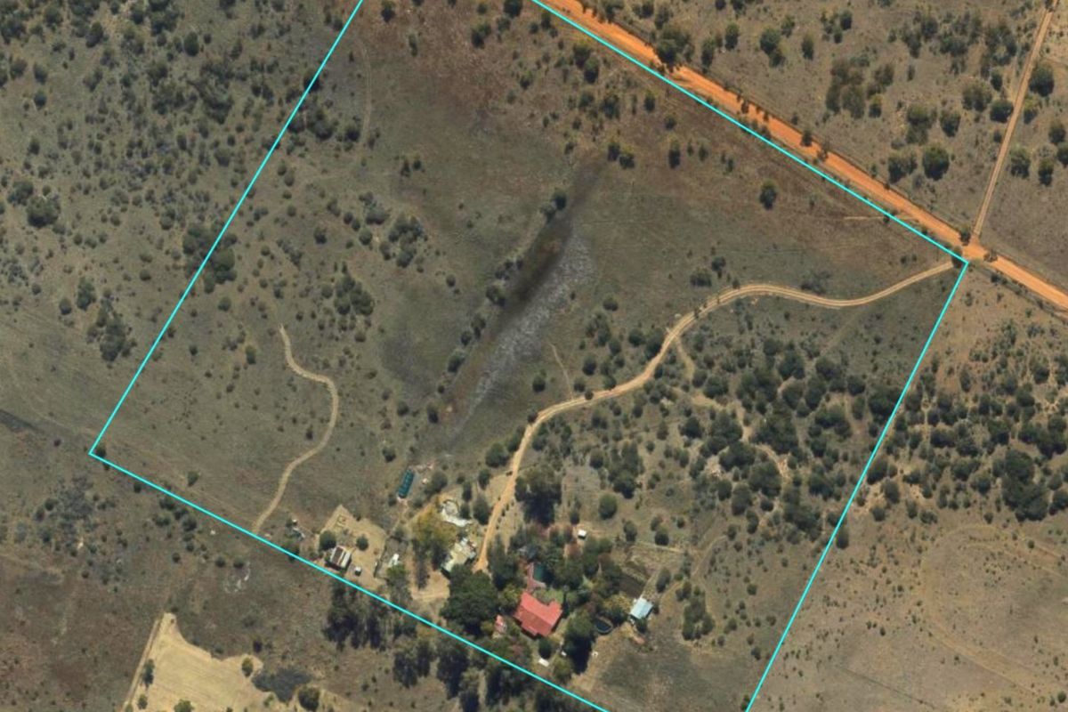Aerial view of the farm property showing the land boundaries, access roads, and existing farm building structures.