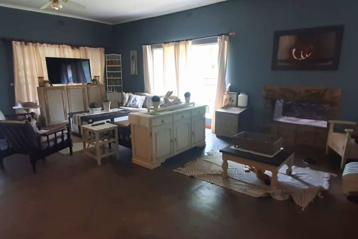 Spacious living room featuring a stone fireplace, ceiling fan, and large sliding glass doors providing natural light.