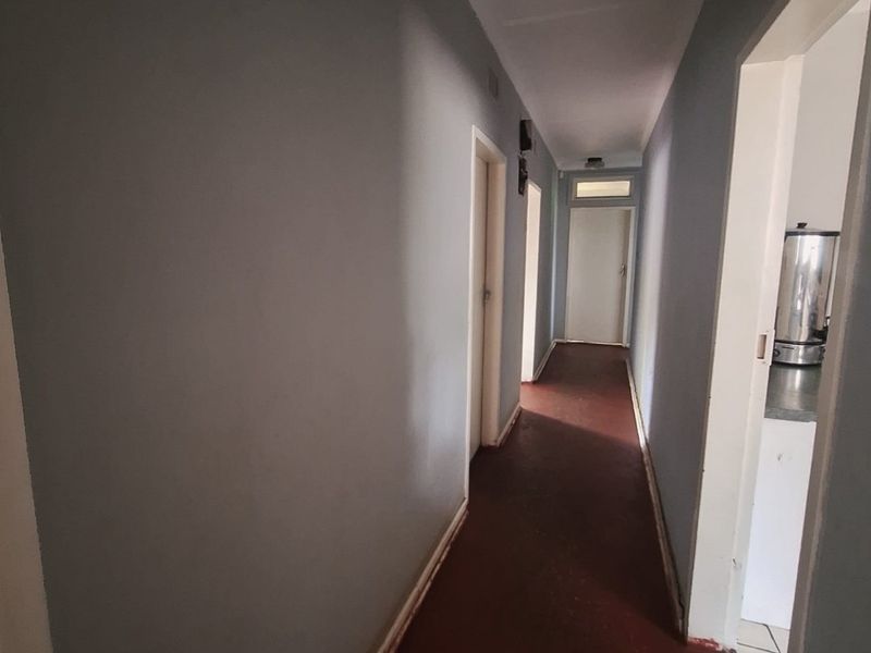A functional hallway connecting multiple rooms, featuring painted walls and durable flooring, providing access throughout the home.