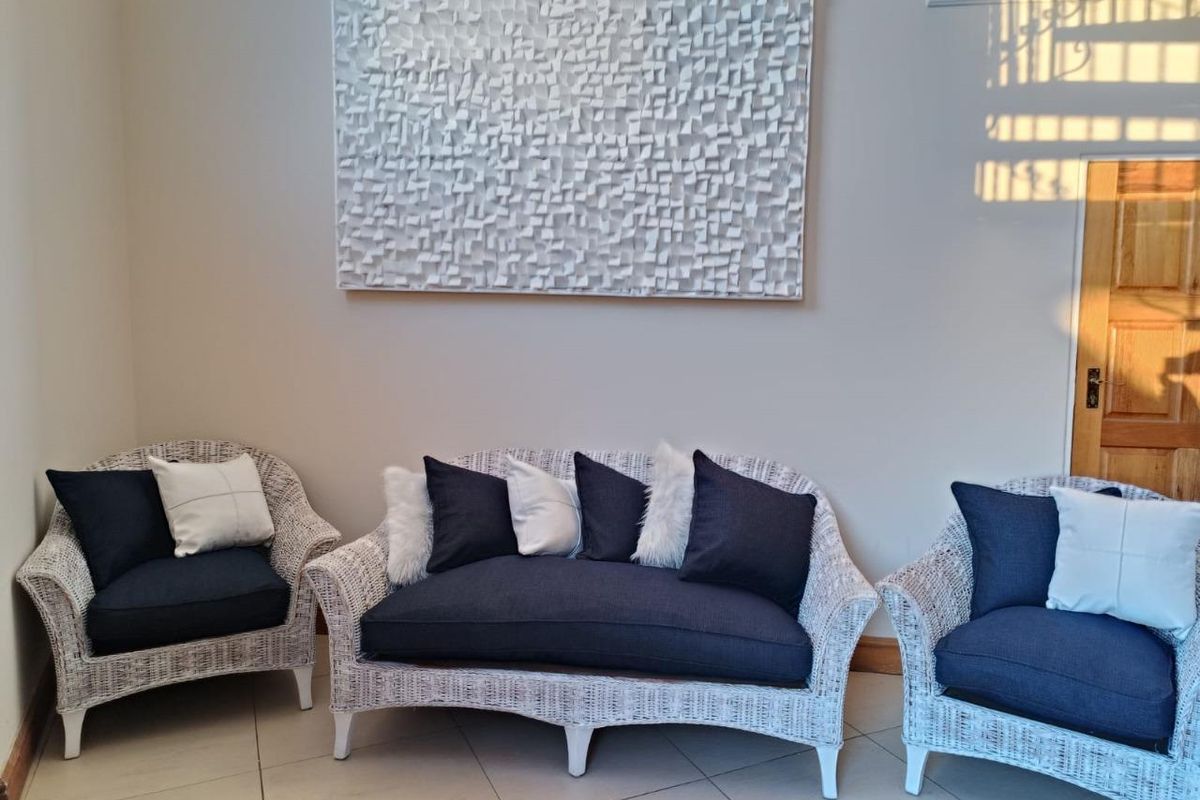 A bright living area featuring neutral tiled flooring, clean wall finishes, and a solid timber door, creating a welcoming and well-maintained space.