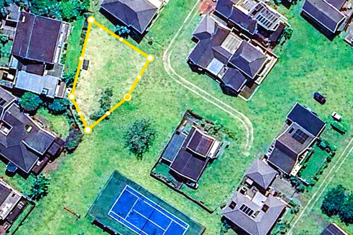 Aerial view of a vacant residential land plot situated within a developed neighborhood.