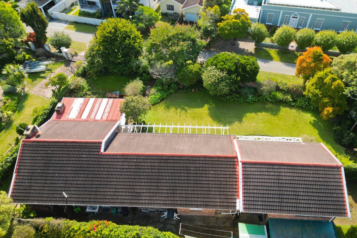 Aerial view of the property showing the main roof structure, rear garden area, and surrounding neighborhood landscape.