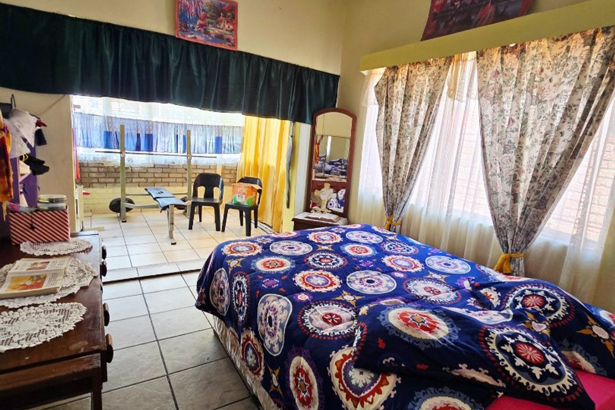 A bedroom featuring tiled flooring and direct access to an adjoining patio area through a sliding door.