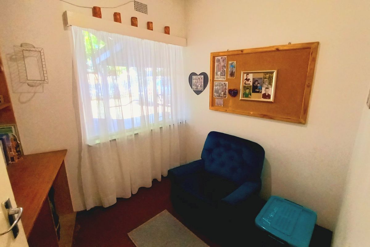 A compact bedroom featuring built-in shelving and a desk area, providing functional storage and workspace within the room.
