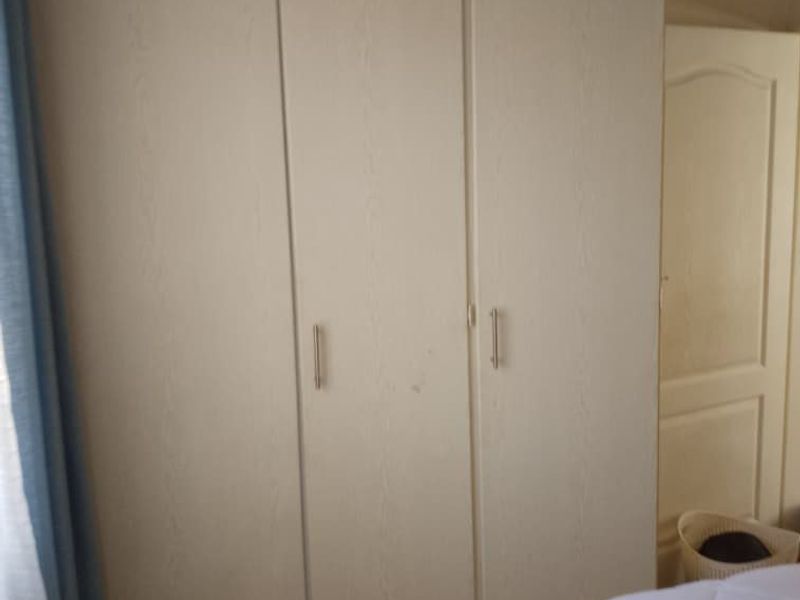 A bedroom featuring a built-in wardrobe with white finish doors.