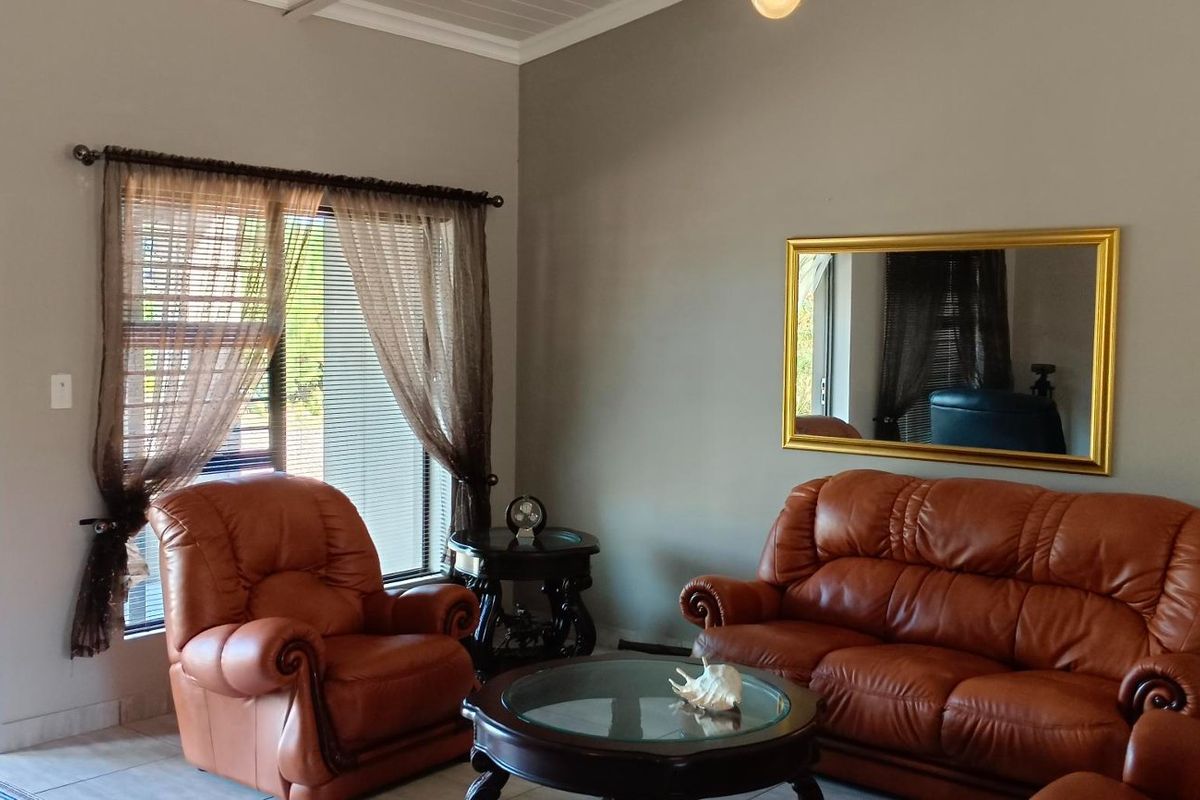 A living room featuring tiled flooring, a sliding glass door providing outdoor access, and coved ceiling detailing.