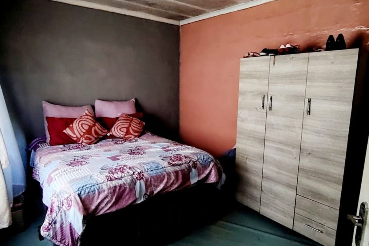A bedroom featuring a basic layout with painted walls and a tiled ceiling, requiring cosmetic updates to improve the overall finish and condition.