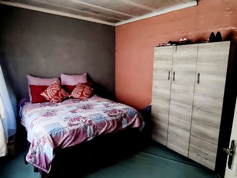A bedroom featuring a basic layout with painted walls and a tiled ceiling, requiring cosmetic updates to improve the overall finish and condition.