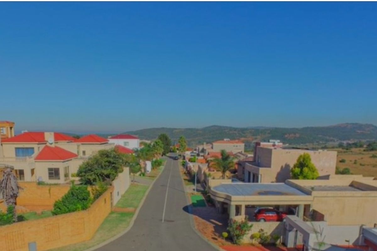 An aerial view of a residential street in a suburban neighborhood, showcasing the surrounding houses and local landscape.