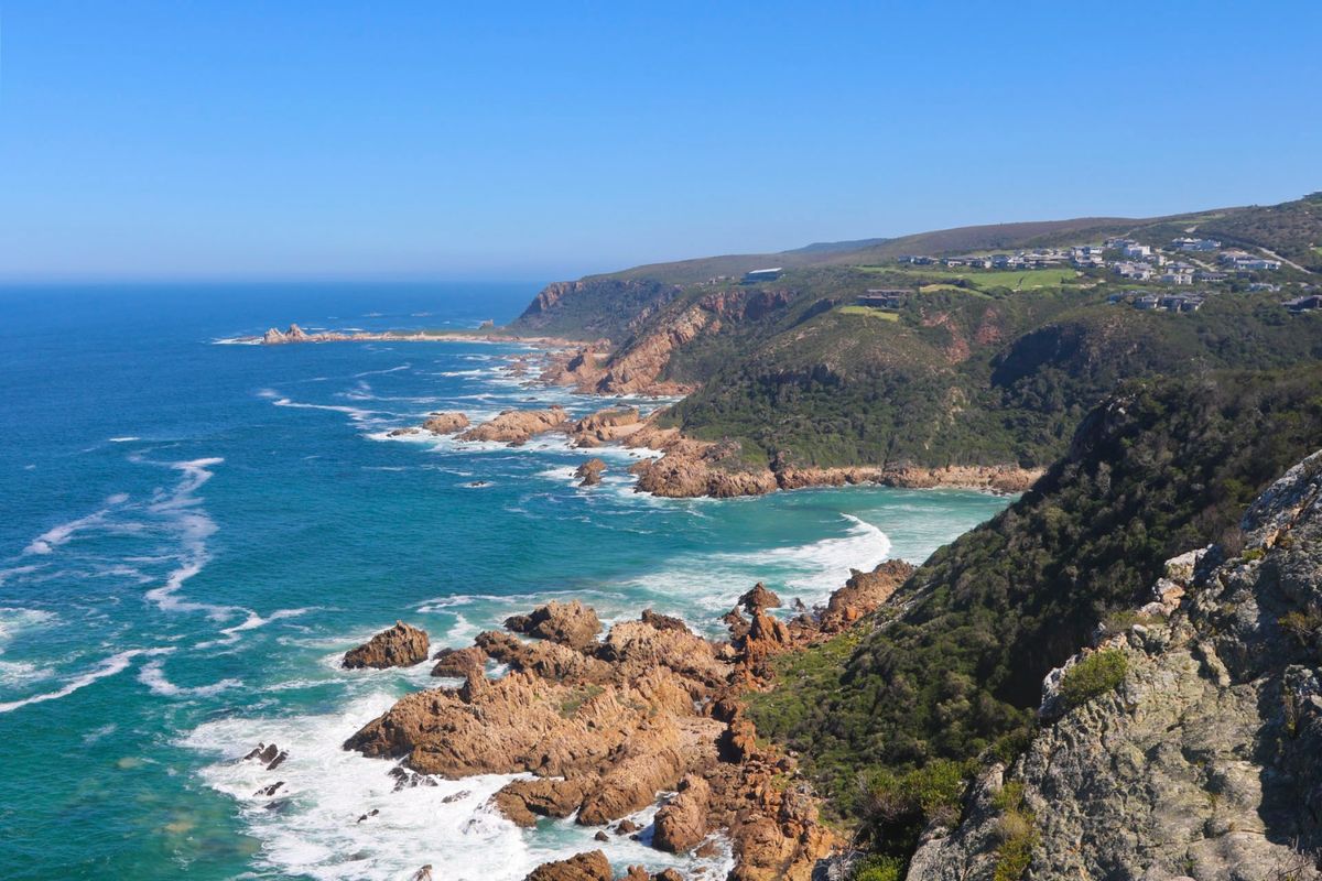 A scenic coastal view overlooking the rugged shoreline, rocky cliffs, and the ocean, showcasing the natural landscape of the property area.