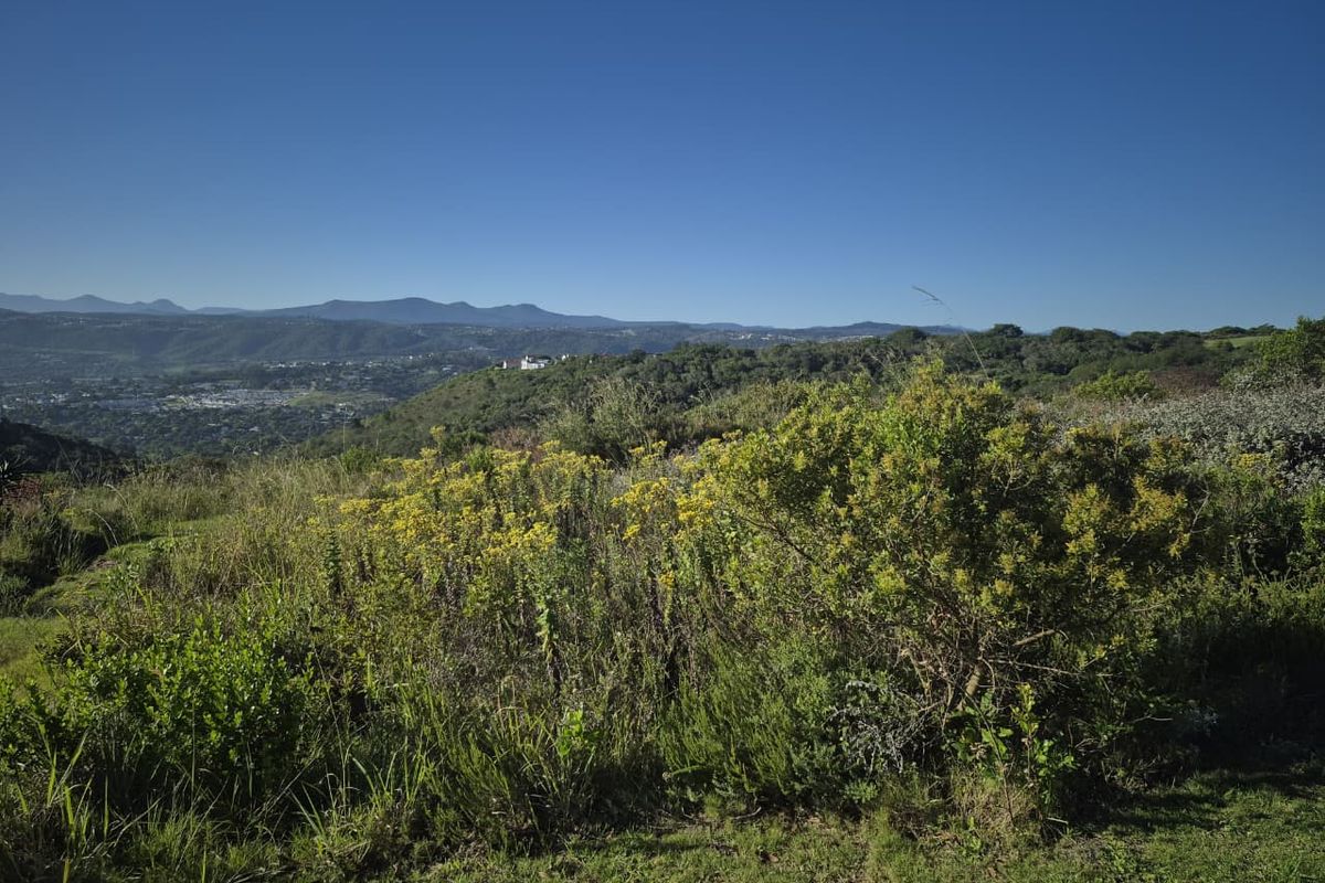 A scenic elevated view of the surrounding natural landscape, rolling hills, and distant mountain range.