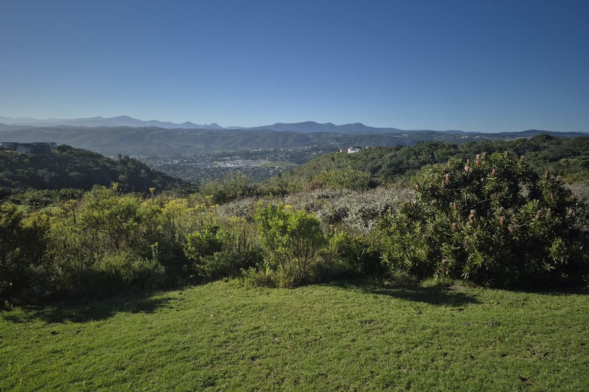 A scenic, elevated view overlooking a lush valley and distant mountain range, showcasing the natural landscape of the vacant residential property.