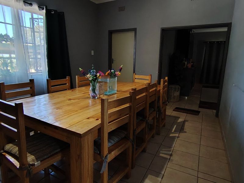 A dining room featuring tiled flooring and natural light from a window, providing a functional space for family meals.