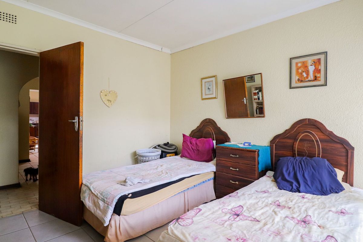 A functional bedroom featuring tiled flooring and a standard interior door, providing a neutral space ready for cosmetic updates.