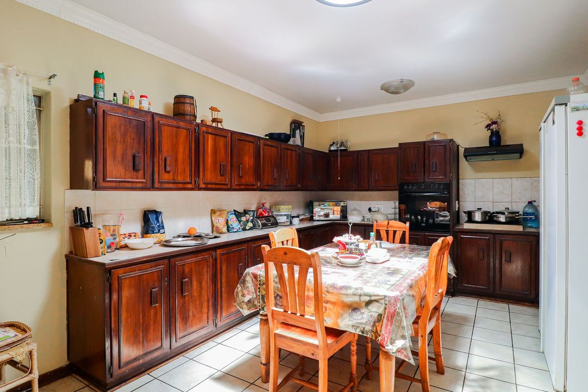 A functional kitchen featuring traditional wooden cabinetry, tiled flooring, and a built-in oven, offering a classic layout with ample storage space.