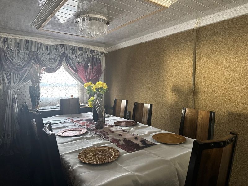 A dining room featuring decorative ceiling panels, crown molding, and textured wall finishes, providing a formal space for meals.
