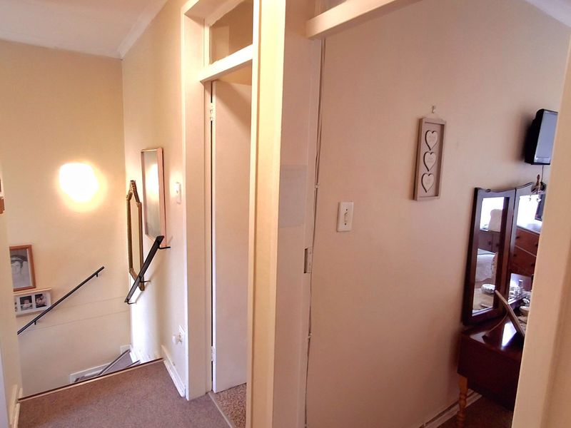 A functional hallway area featuring a staircase with a handrail, providing access to adjacent rooms through internal doors.