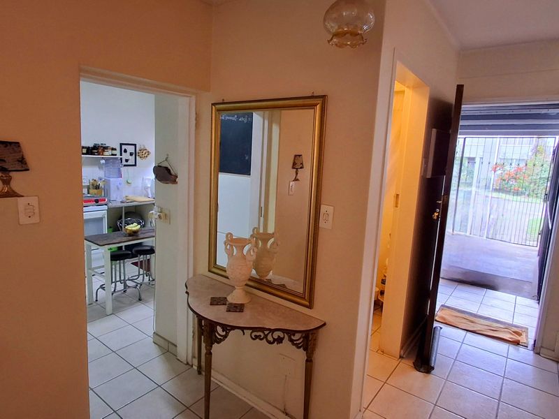 A functional hallway area featuring tiled flooring, providing access to the kitchen and main entrance of the apartment.