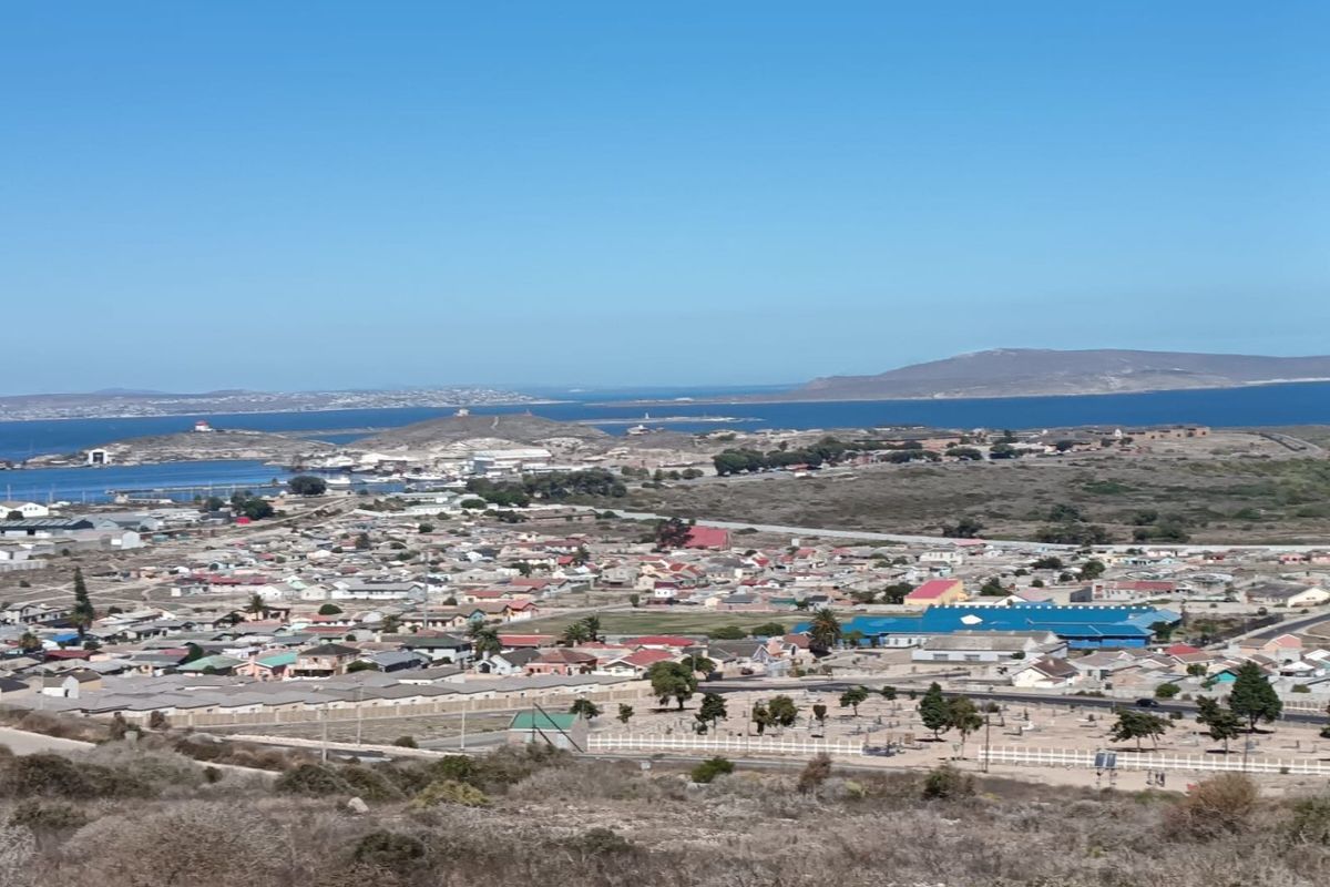 A wide-angle elevated view overlooking a coastal residential area and the surrounding landscape.