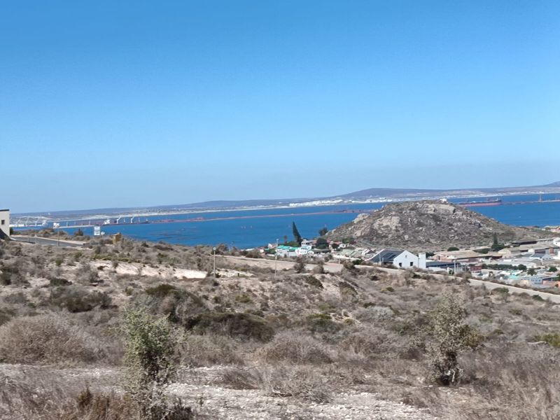 A scenic elevated view overlooking the coastal landscape, ocean, and surrounding residential area.