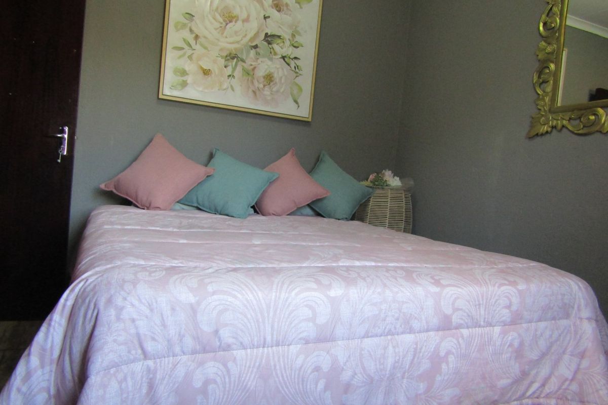 A bedroom featuring neutral wall tones and decorative coving, providing a comfortable and functional sleeping space.