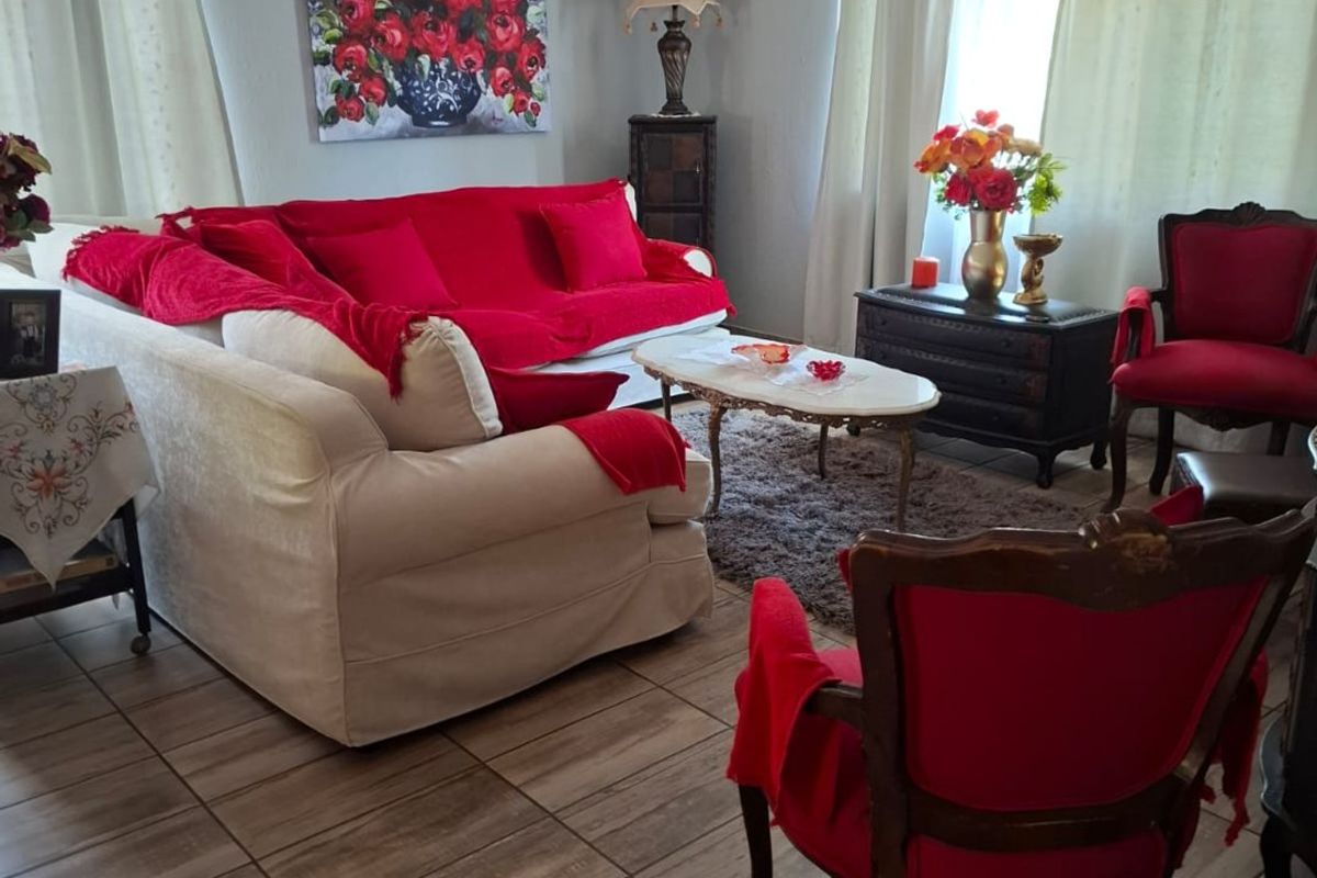 A comfortable living room featuring tiled flooring and a wall-mounted split-system air conditioner, providing a functional and climate-controlled space.
