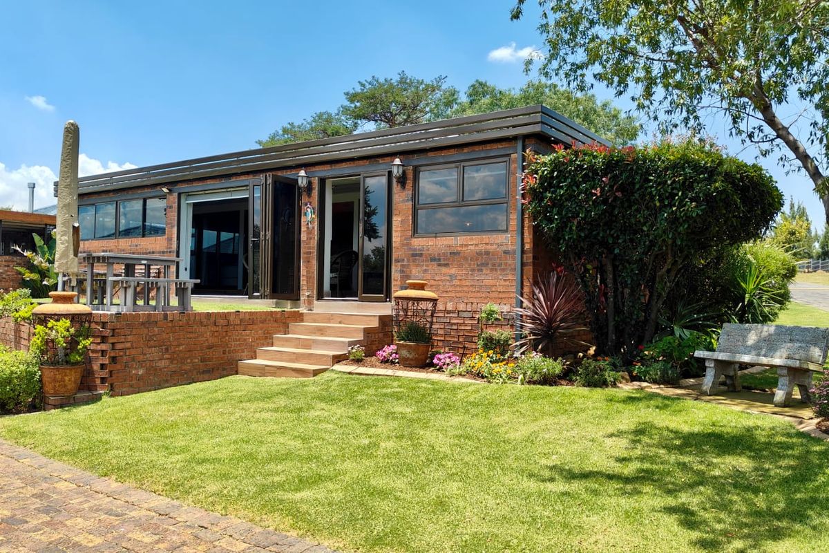 A well-maintained face brick exterior featuring a raised patio, bi-fold doors, and landscaped garden area, showcasing a modern and durable building finish.