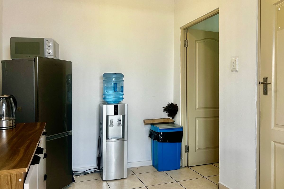 A functional kitchen area featuring tiled flooring and access to an adjacent room through a standard internal door.