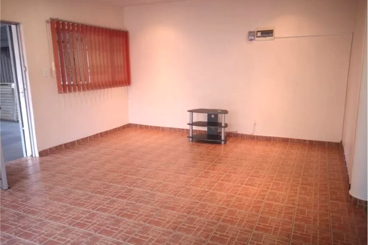 A spacious, empty living area featuring tiled flooring, vertical blinds, and recessed lighting, providing a blank canvas for interior design.