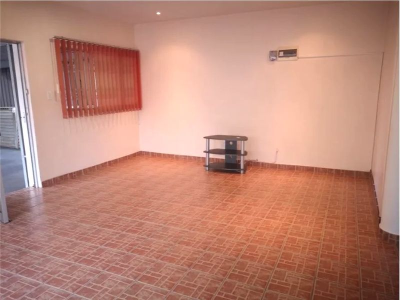 A spacious, empty living area featuring tiled flooring, vertical blinds, and recessed lighting, providing a blank canvas for interior design.