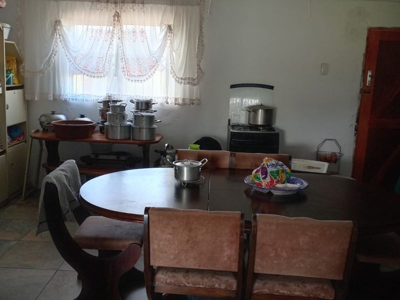 A dining area featuring tiled flooring and a freestanding stove, requiring cosmetic updates to improve the overall aesthetic and condition of the space.