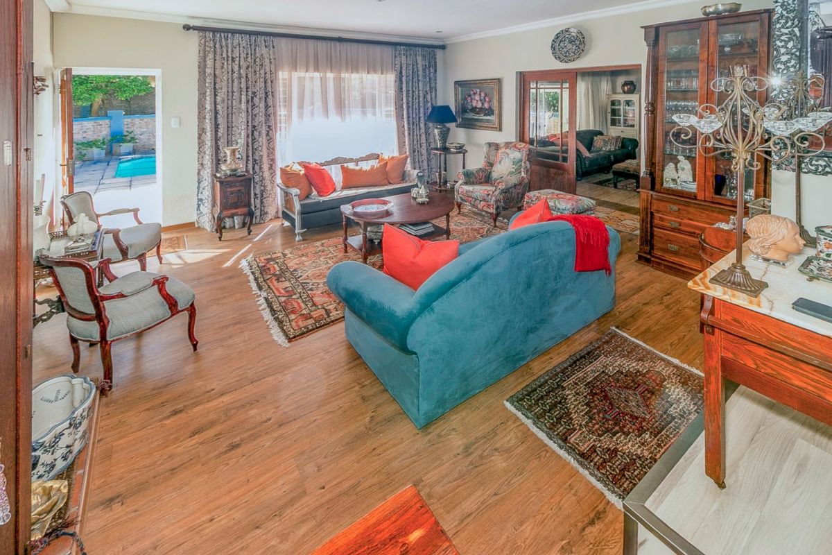 Spacious living room featuring laminate flooring, recessed lighting, and direct access to an outdoor patio area through a sliding glass door.