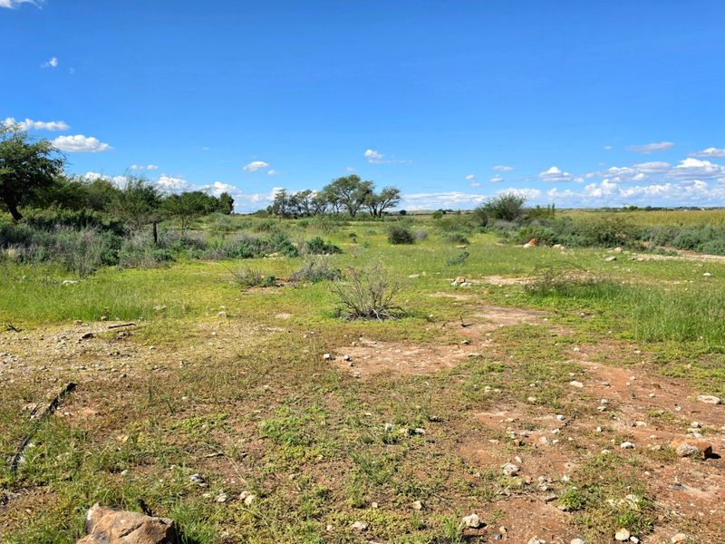 A view of an undeveloped residential plot featuring natural vegetation and open terrain, suitable for future construction.