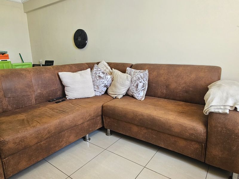 A living room area featuring neutral wall finishes and tiled flooring, providing a functional space for relaxation.