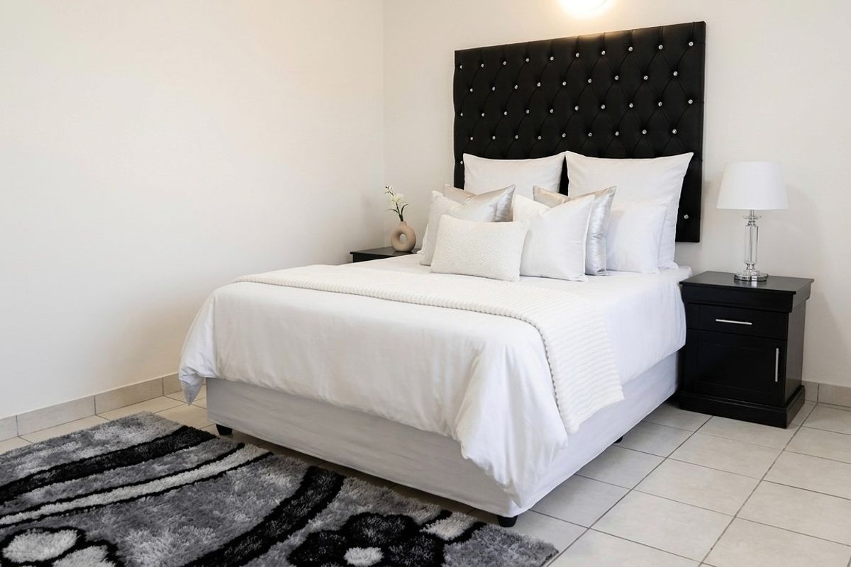 A well-maintained bedroom featuring neutral tiled flooring and a clean, minimalist aesthetic.