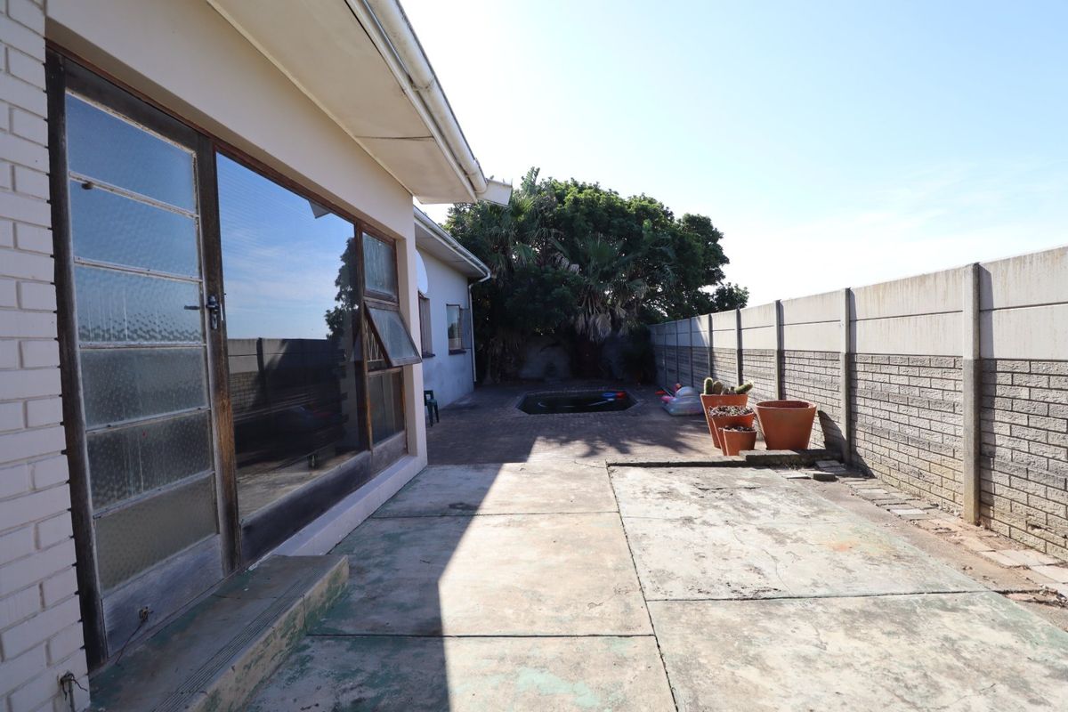 Rear exterior area featuring a concrete patio, boundary wall, and a small plunge pool, providing a private outdoor space with potential for landscaping.
