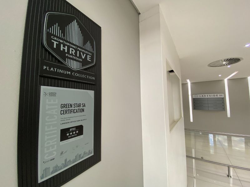 Modern commercial building entrance lobby featuring professional signage, Green Star certification plaque, and clean, well-maintained tiled flooring and recessed lighting.