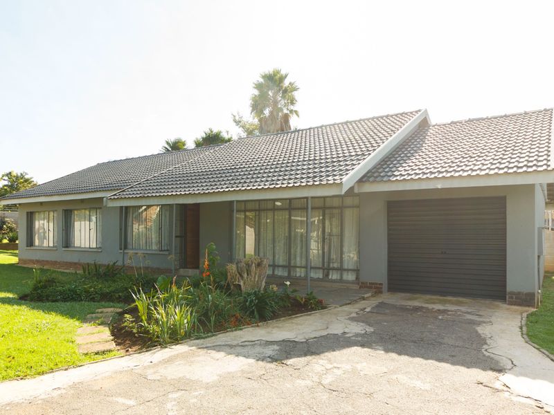 Single-story residential home featuring a tiled roof, integrated garage, and established front garden with a paved driveway.