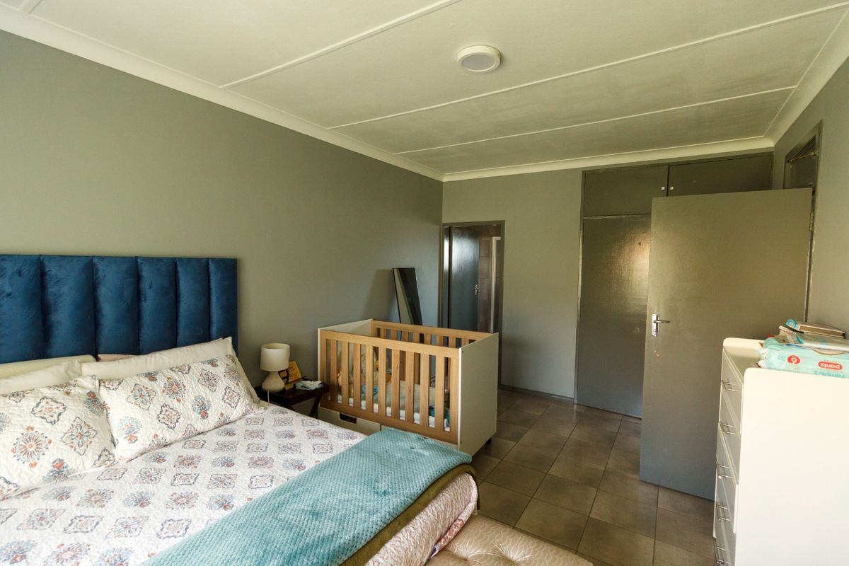 A bedroom featuring tiled flooring, built-in cupboards, and a ceiling-mounted light fixture.