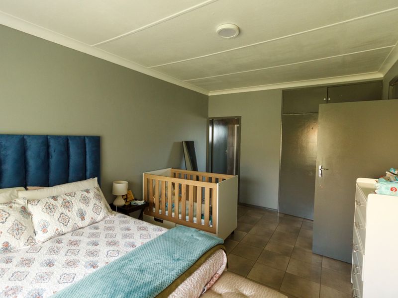 A bedroom featuring tiled flooring, built-in cupboards, and a ceiling-mounted light fixture.
