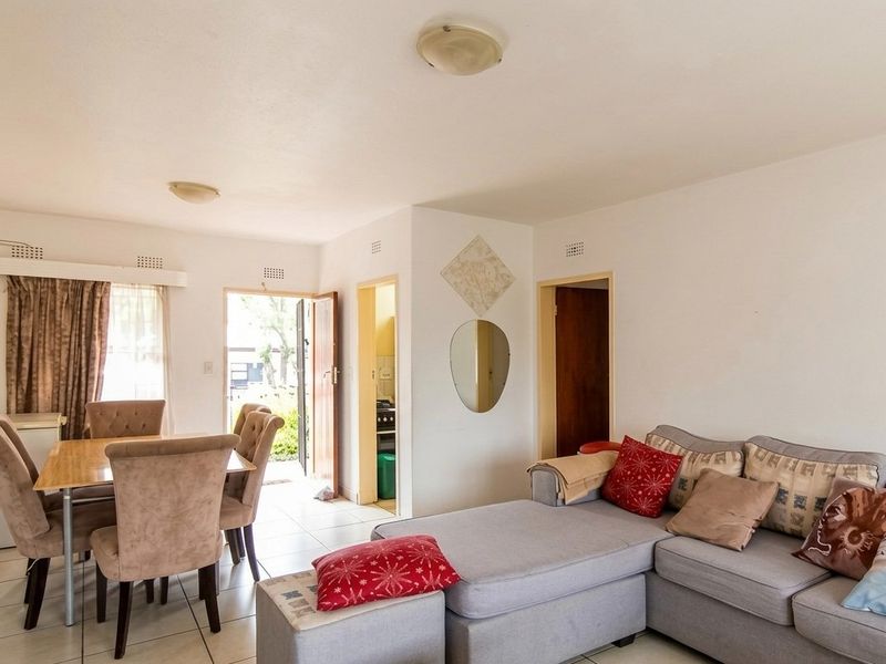 Open plan living and dining area featuring tiled flooring and direct access to the kitchen and exterior entrance.