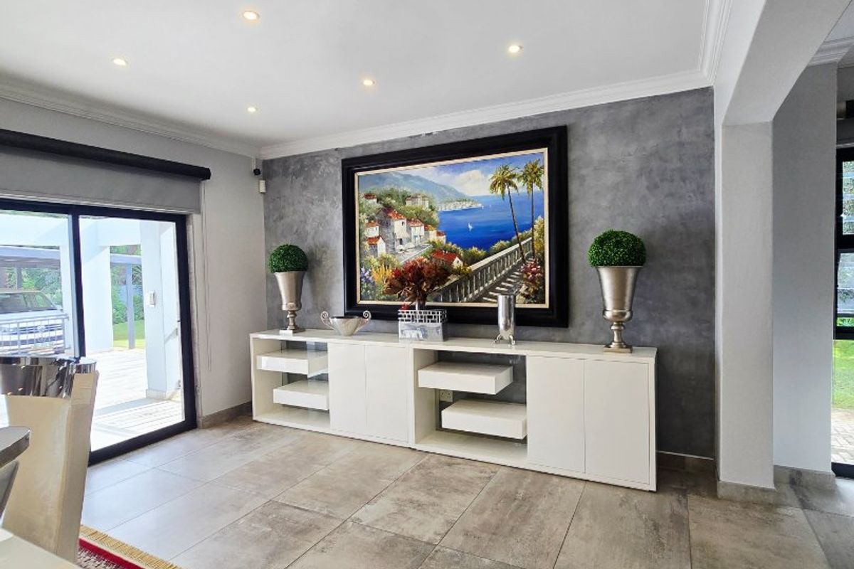 A well-maintained living area featuring large format floor tiles, a textured feature wall, recessed lighting, and a sliding door providing access to the exterior.