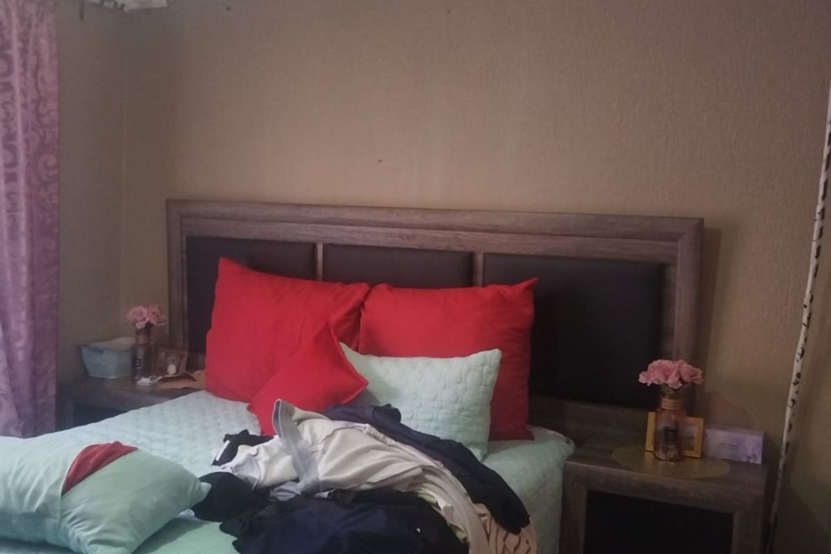 A bedroom featuring a built-in headboard and cove cornice detailing.