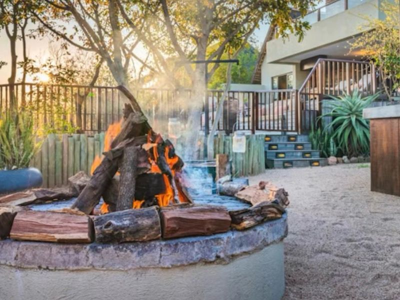 A well-maintained outdoor garden area featuring a circular built-in fire pit, stone steps, and timber balustrades, creating an inviting space for outdoor relaxation.