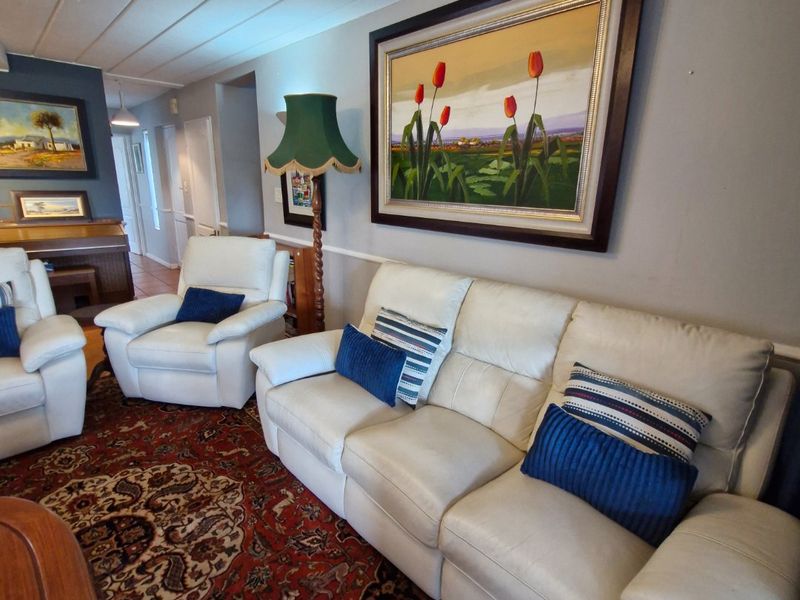 A comfortable living room featuring a tongue and groove ceiling and classic chair rail molding, providing a traditional foundation for the space.