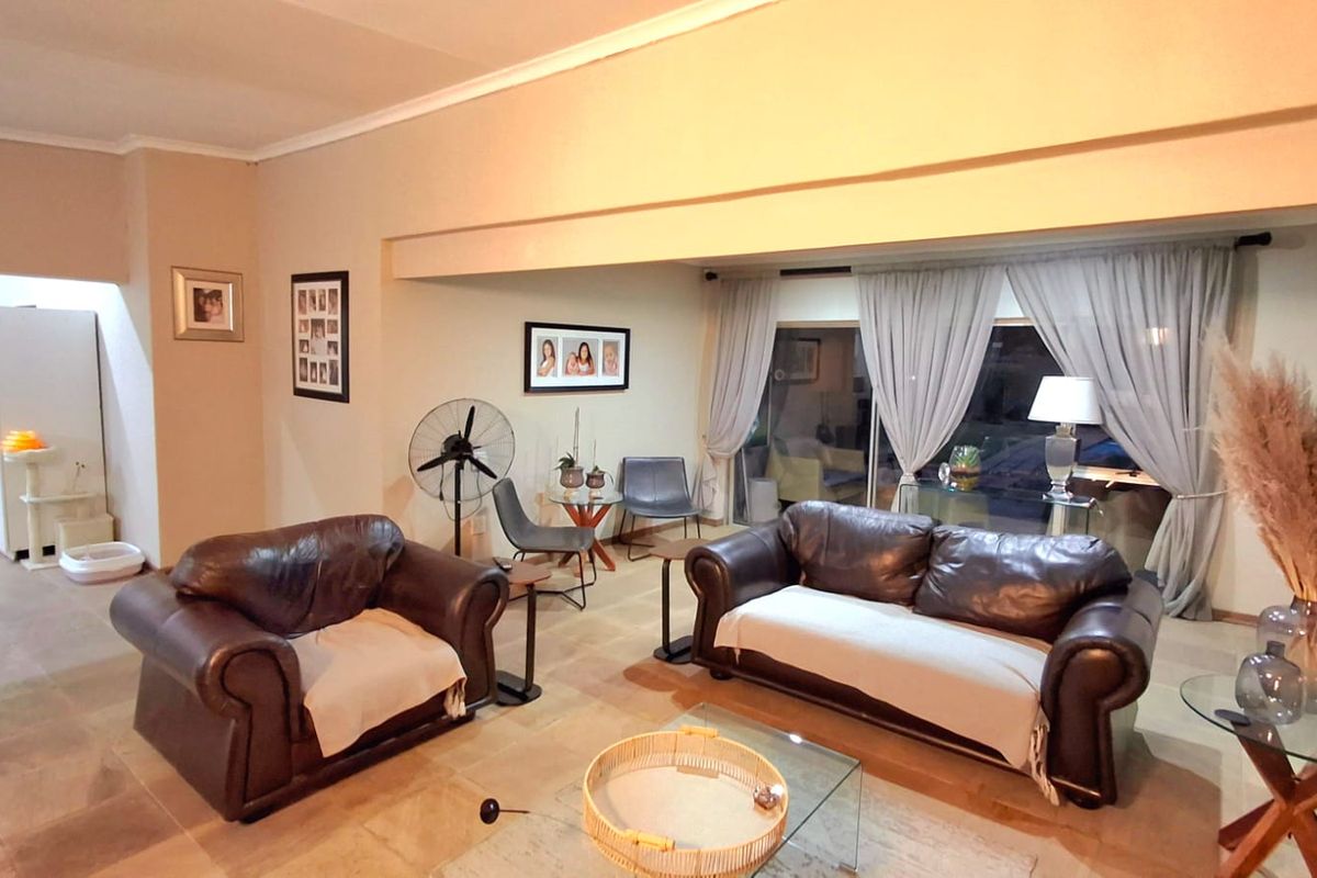 Spacious living room featuring tiled flooring and large sliding glass doors that provide natural light and access to the outdoor area.