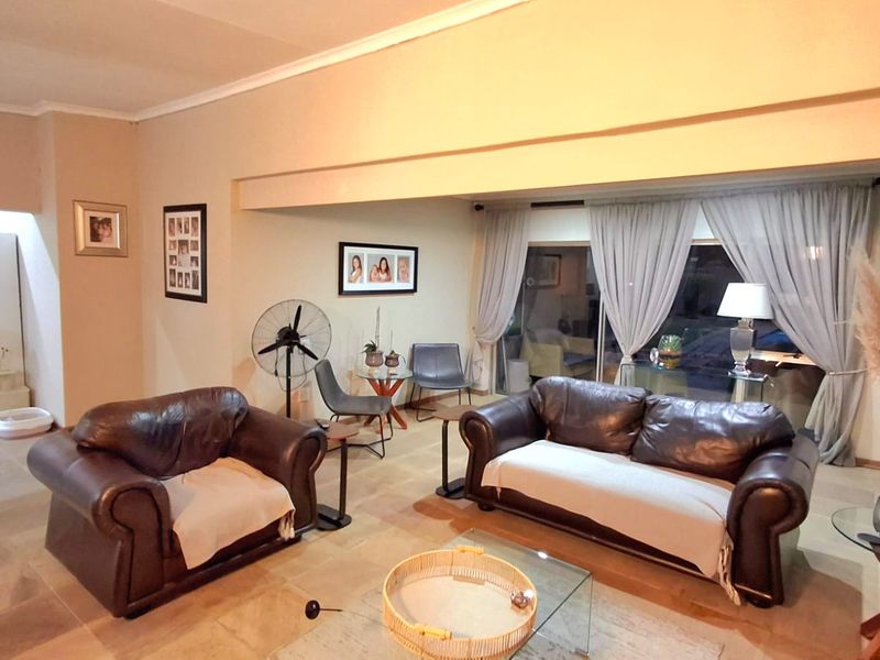 Spacious living room featuring tiled flooring and large sliding glass doors that provide natural light and access to the outdoor area.