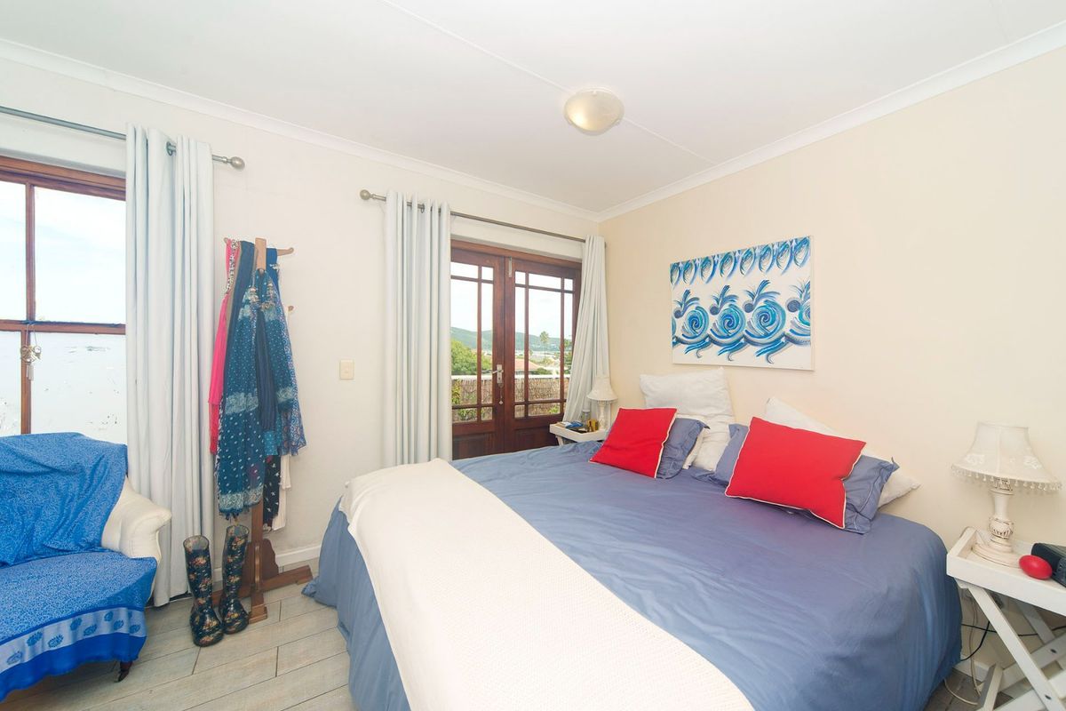 A bedroom featuring tiled flooring, coved cornicing, and timber-framed glass doors providing access to the exterior.