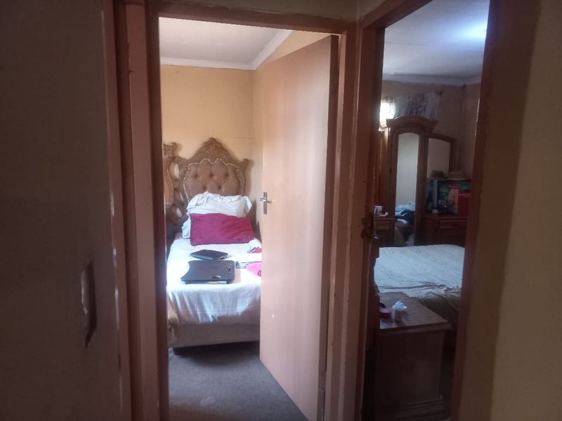 A view from a hallway looking into two separate bedrooms, featuring standard door frames and basic interior finishes.